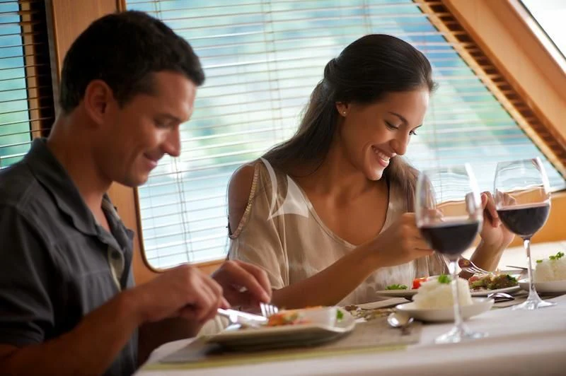 a man and a woman eating at a table aboard MISS KULANI Yacht for Charter