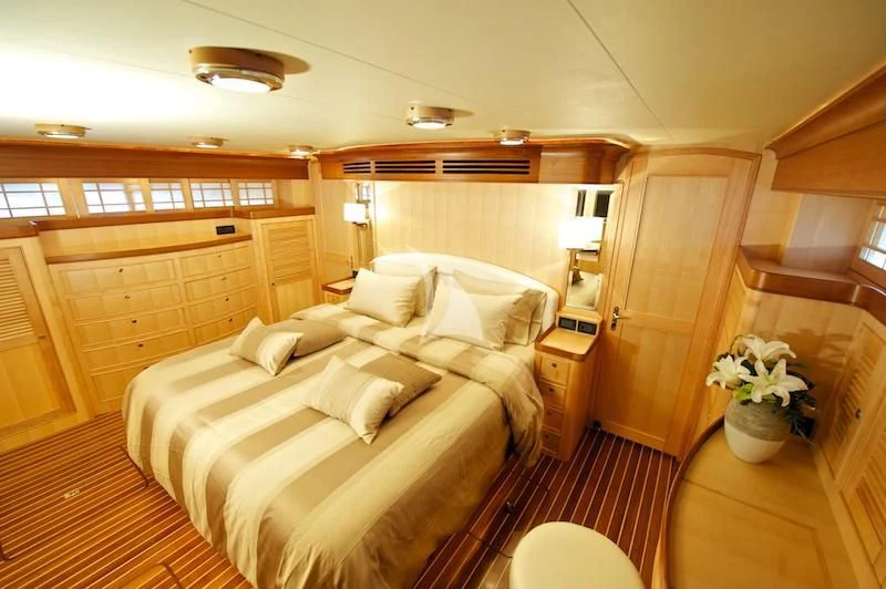 a room with a bed and a chair aboard MISS KULANI Yacht for Charter