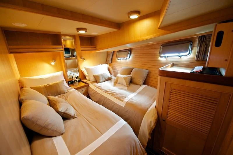 a room with a bed and a television aboard MISS KULANI Yacht for Charter