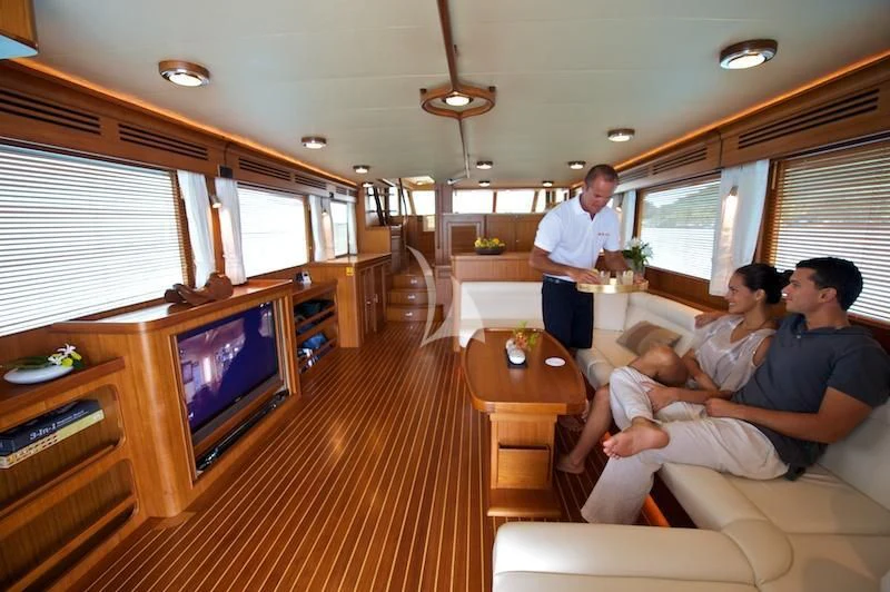 a group of people sitting in a living room watching television aboard MISS KULANI Yacht for Charter