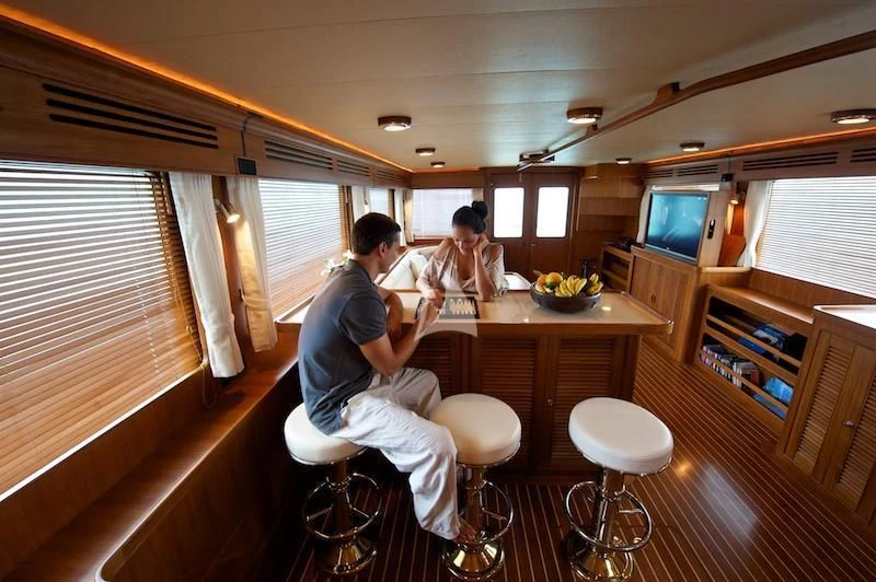 a group of people sitting around a table in a room aboard MISS KULANI Yacht for Charter