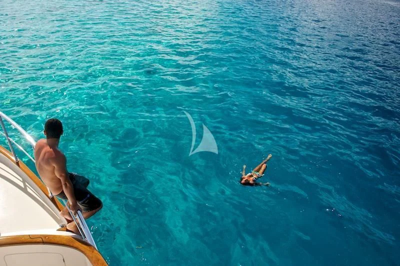 a person and a boy swimming in the water aboard MISS KULANI Yacht for Charter