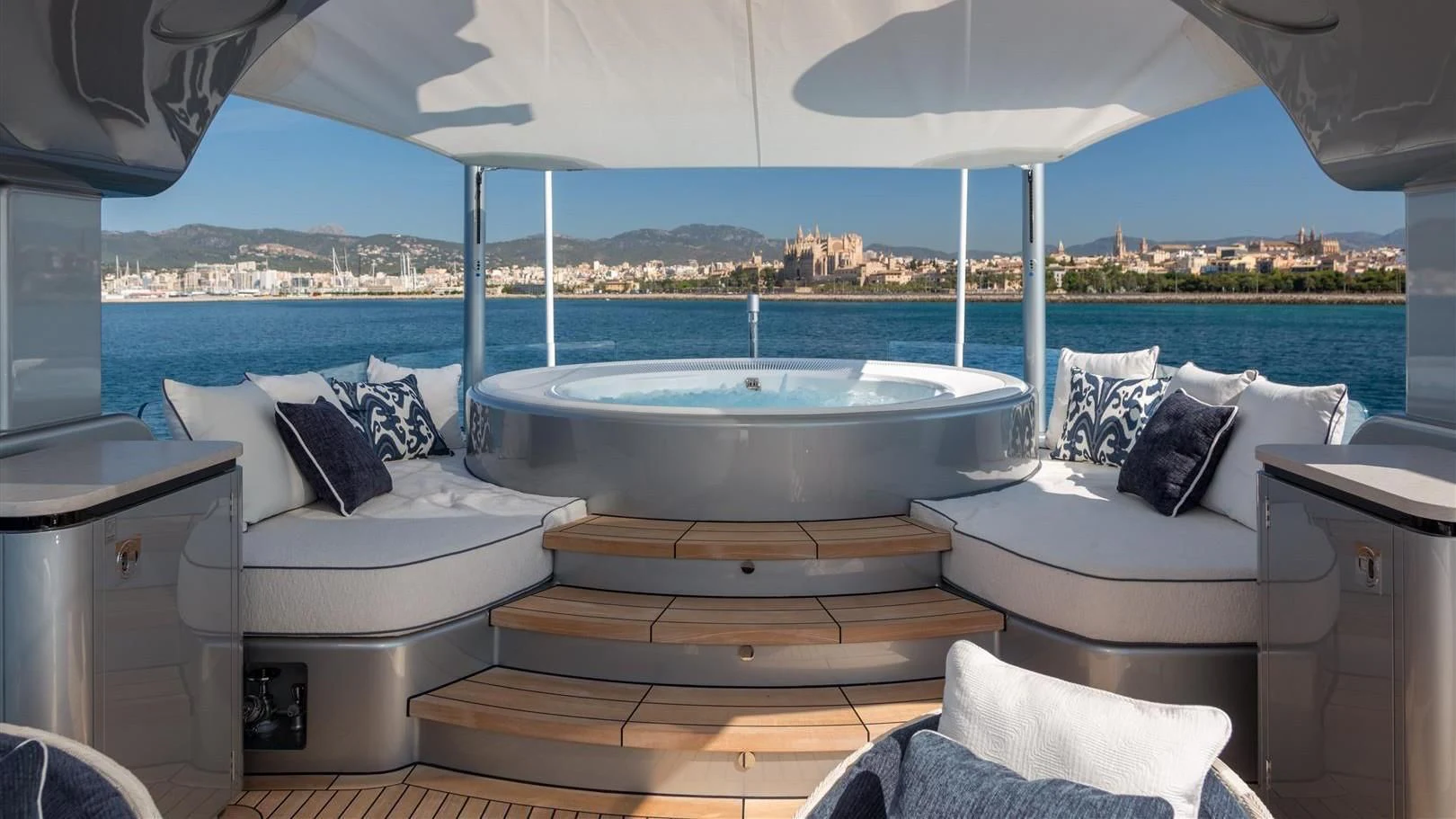 a large white bathtub with pillows and pillows on a patio with a view of the ocean and aboard LADY VICTORIA Yacht for Sale