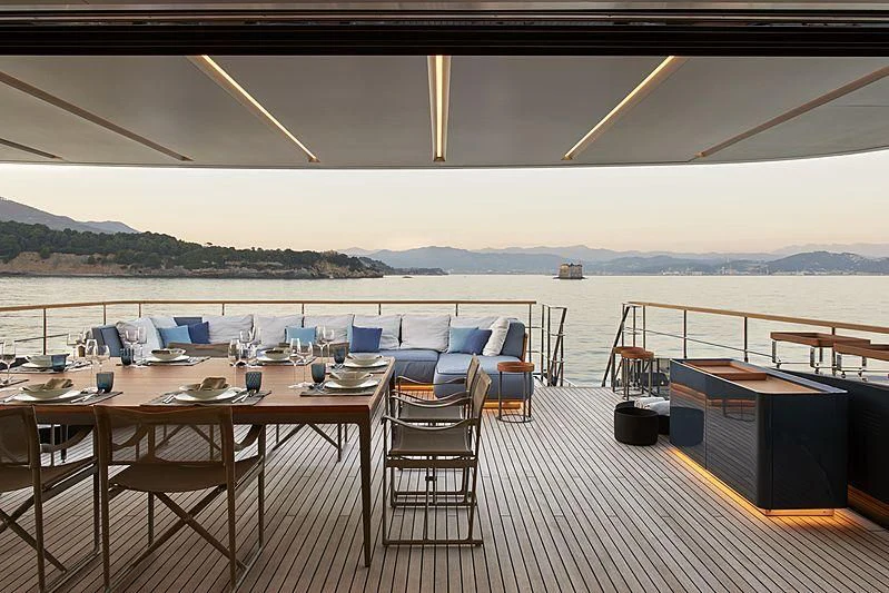 a table set for a meal on a deck overlooking a body of water aboard OCEAN'S FOUR Yacht for Sale