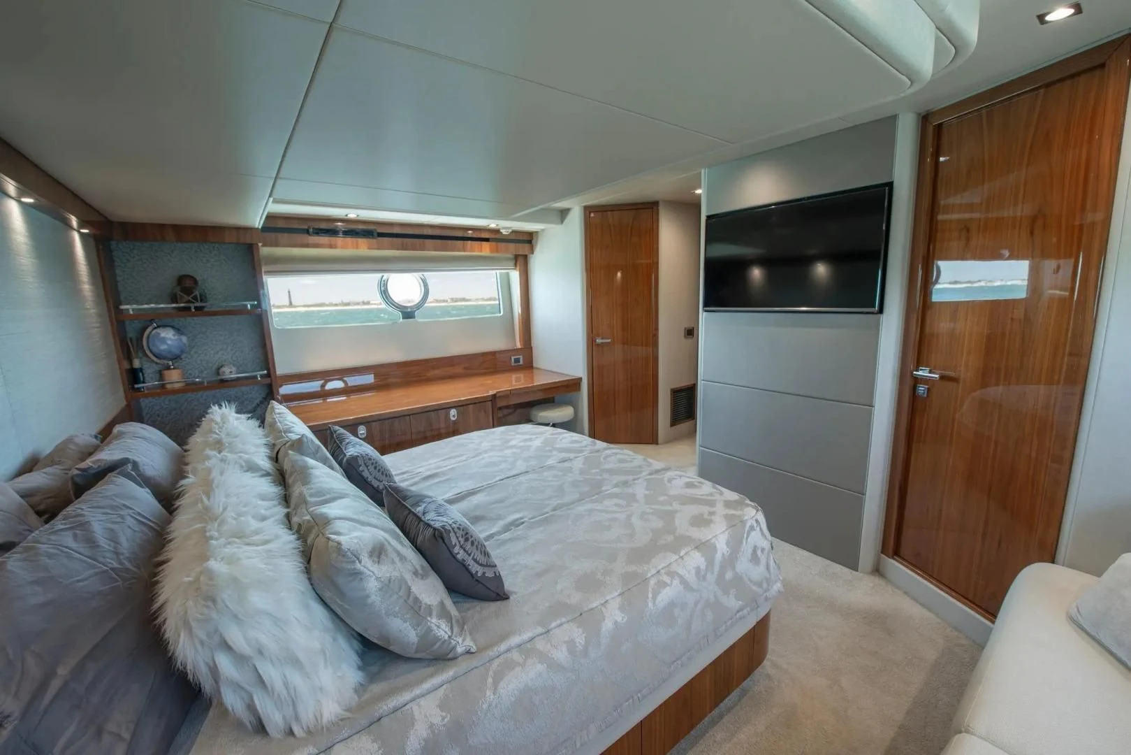 a bedroom with a bed and a wood door aboard LIQUIDITY Yacht for Sale
