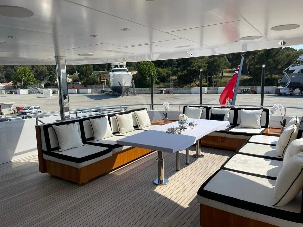 a room with a table chairs and a flag aboard ROCKET Yacht for Sale