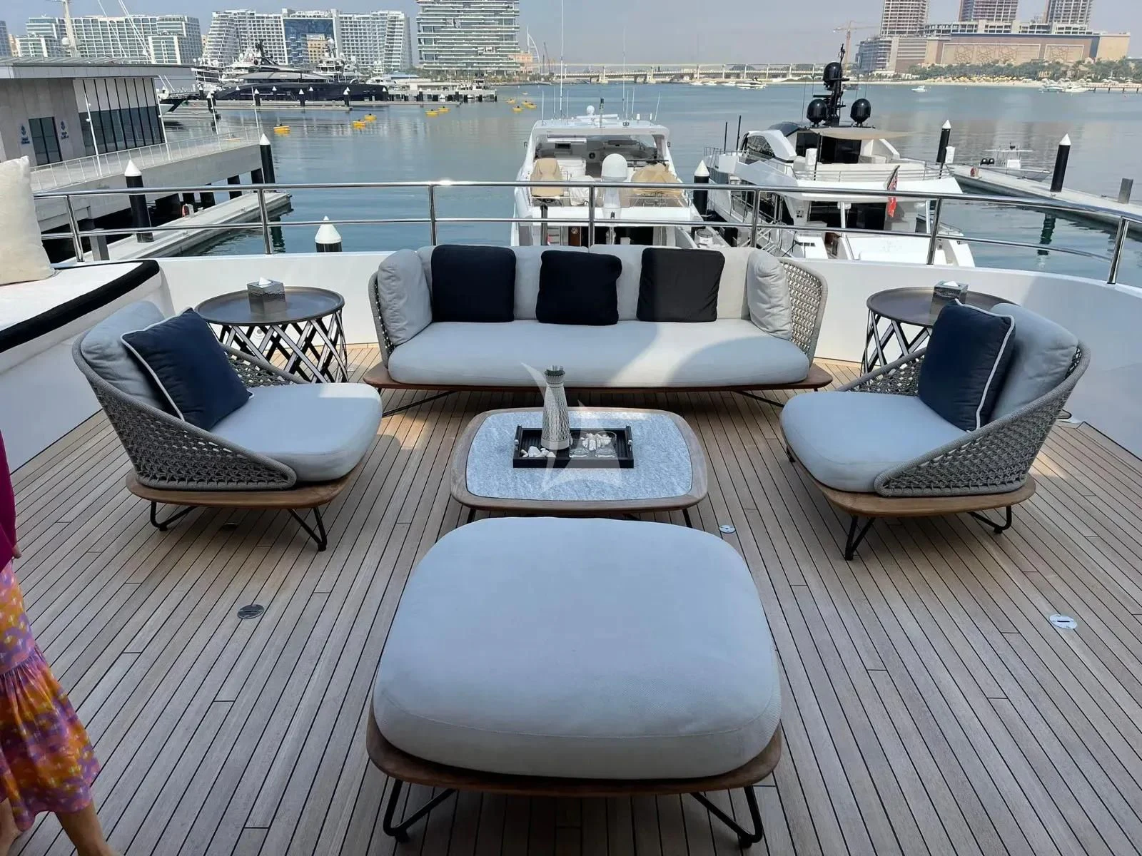 a deck with a table chairs and a boat in the water aboard ROCKET Yacht for Sale