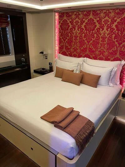 a bed with white sheets and pillows aboard ROCKET Yacht for Sale