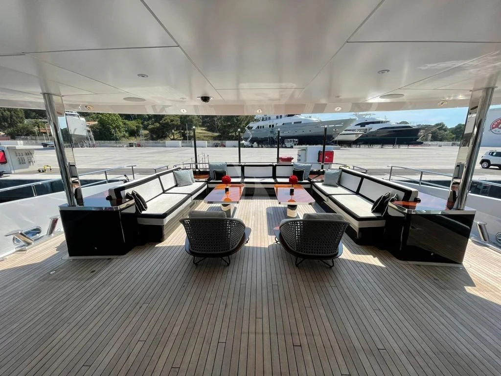 a large room with a bench and a table and chairs aboard ROCKET Yacht for Sale