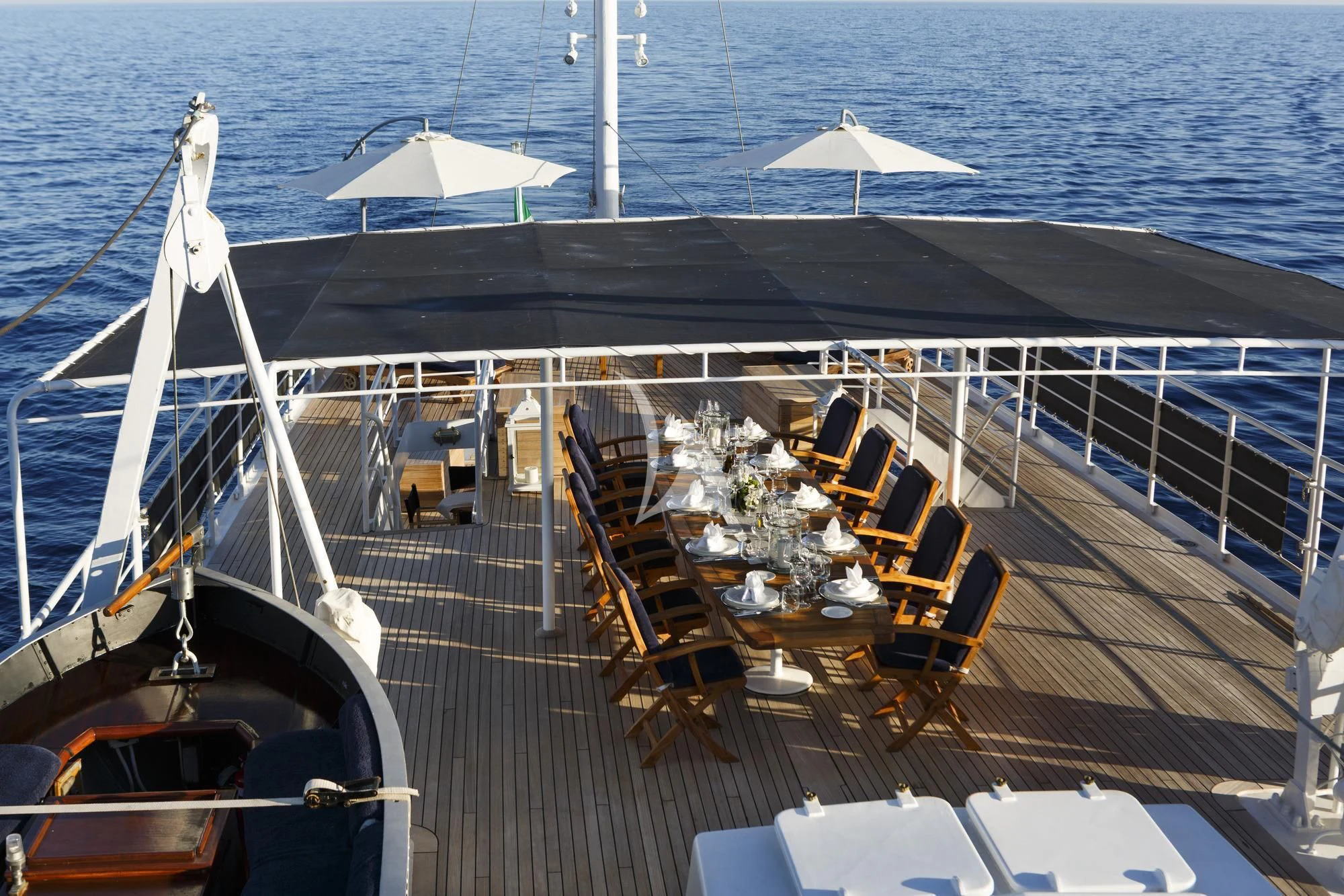 a deck with a table and chairs on it aboard DIONEA Yacht for Sale