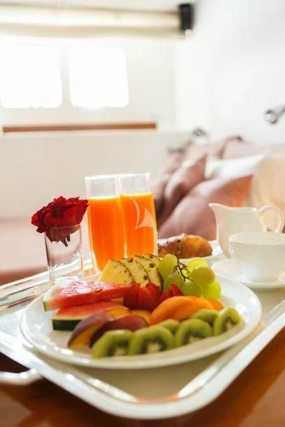 a plate of food and a glass of juice on a table aboard DIONEA Yacht for Sale