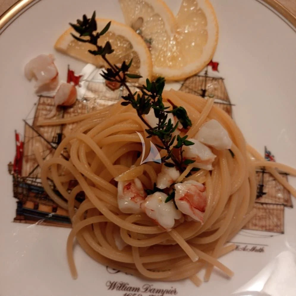 a bowl of noodles with a lemon on top aboard DIONEA Yacht for Sale
