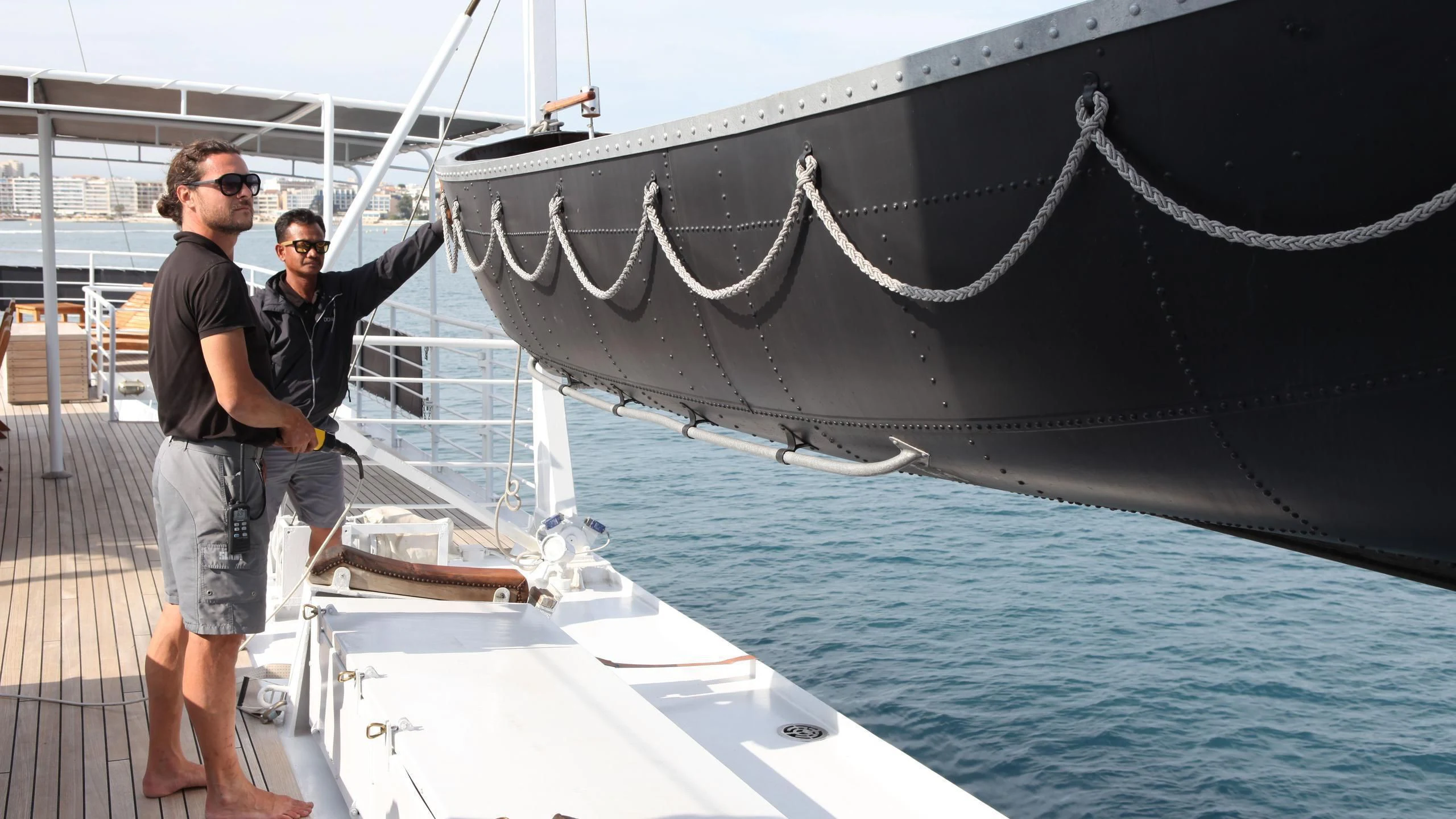 two men standing next to a large sailboat aboard DIONEA Yacht for Sale