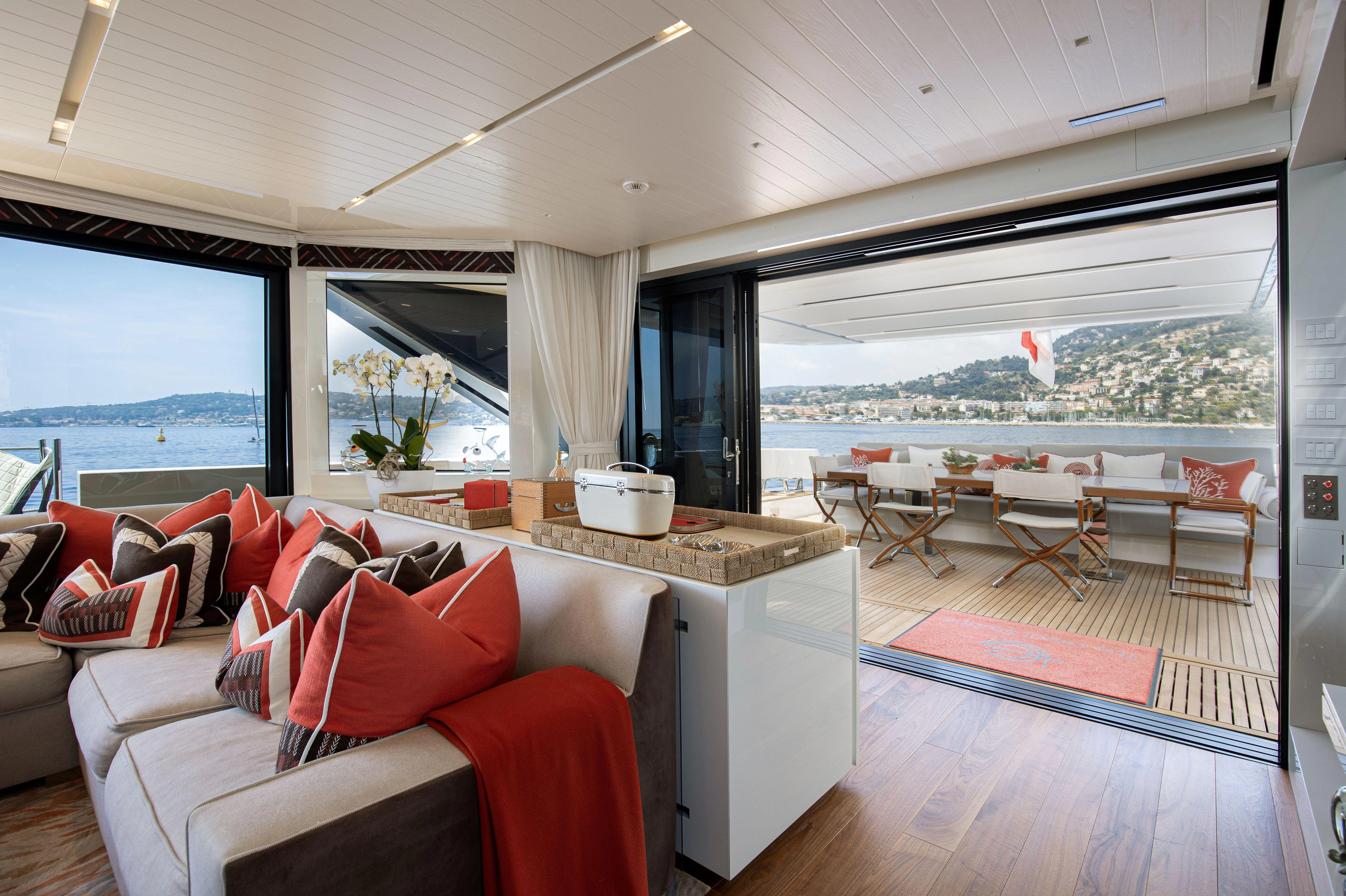 a living room with a red couch aboard ELA & SEA Yacht for Sale