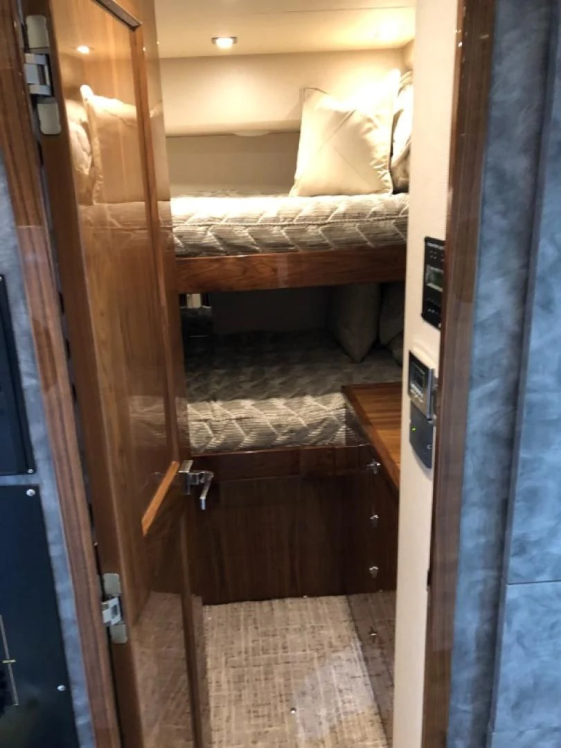 a room with a bed and a door aboard AFTER MIDNIGHT Yacht for Sale