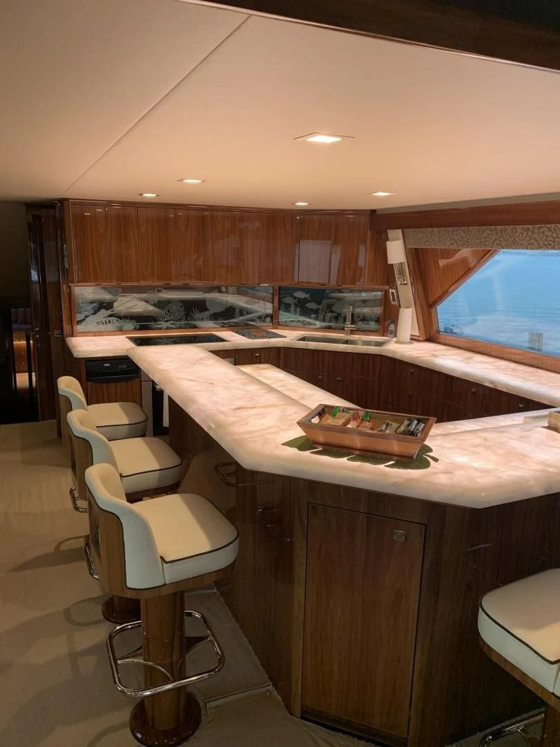 a kitchen with a bar and stools aboard AFTER MIDNIGHT Yacht for Sale