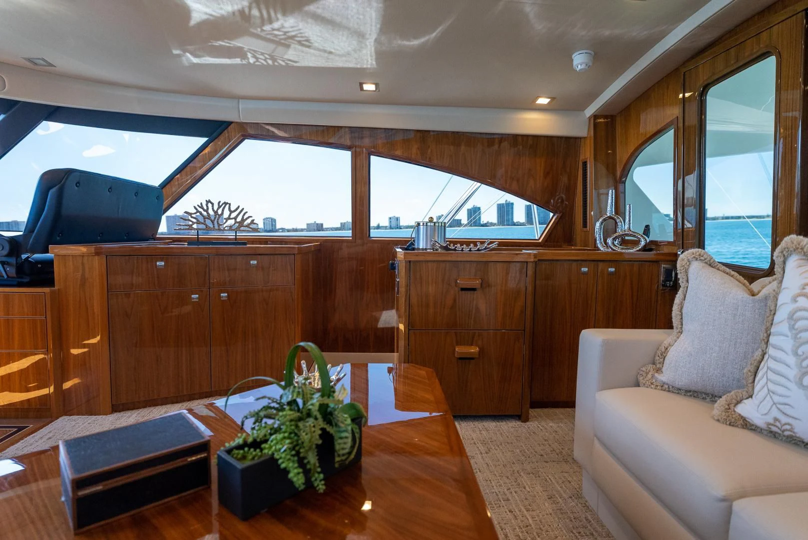 a living room with a wood table and a plant in a pot aboard AFTER MIDNIGHT Yacht for Sale