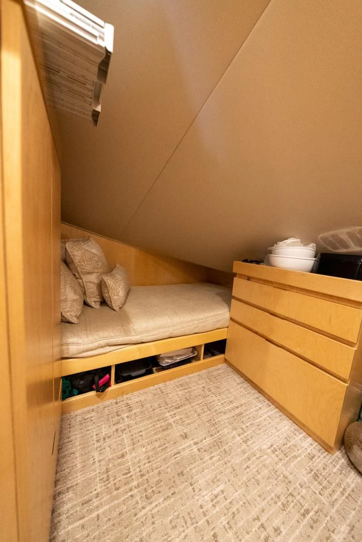 a bed with a couch and a dresser in a room aboard AFTER MIDNIGHT Yacht for Sale