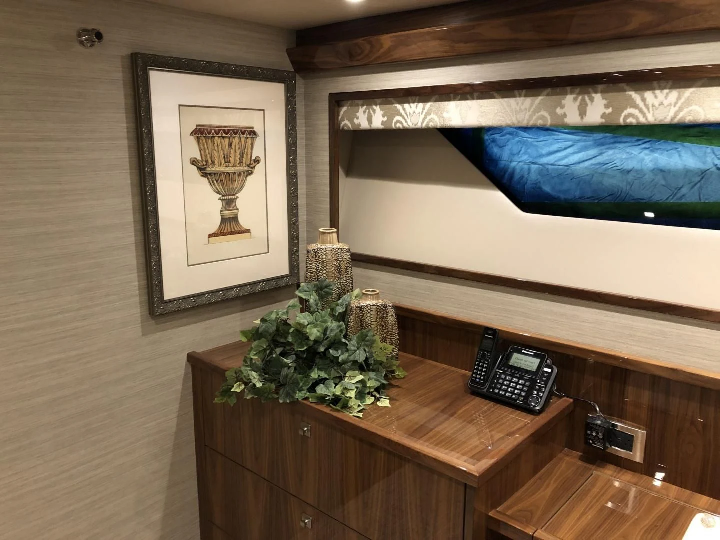 a desk with a phone and a picture on it aboard AFTER MIDNIGHT Yacht for Sale