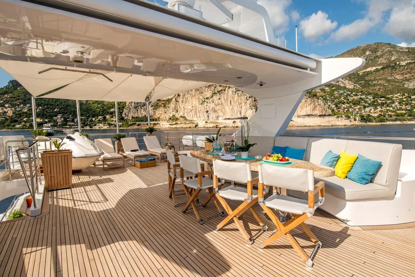 a deck with a large umbrella over it and chairs on it aboard TIAMAT Yacht for Sale
