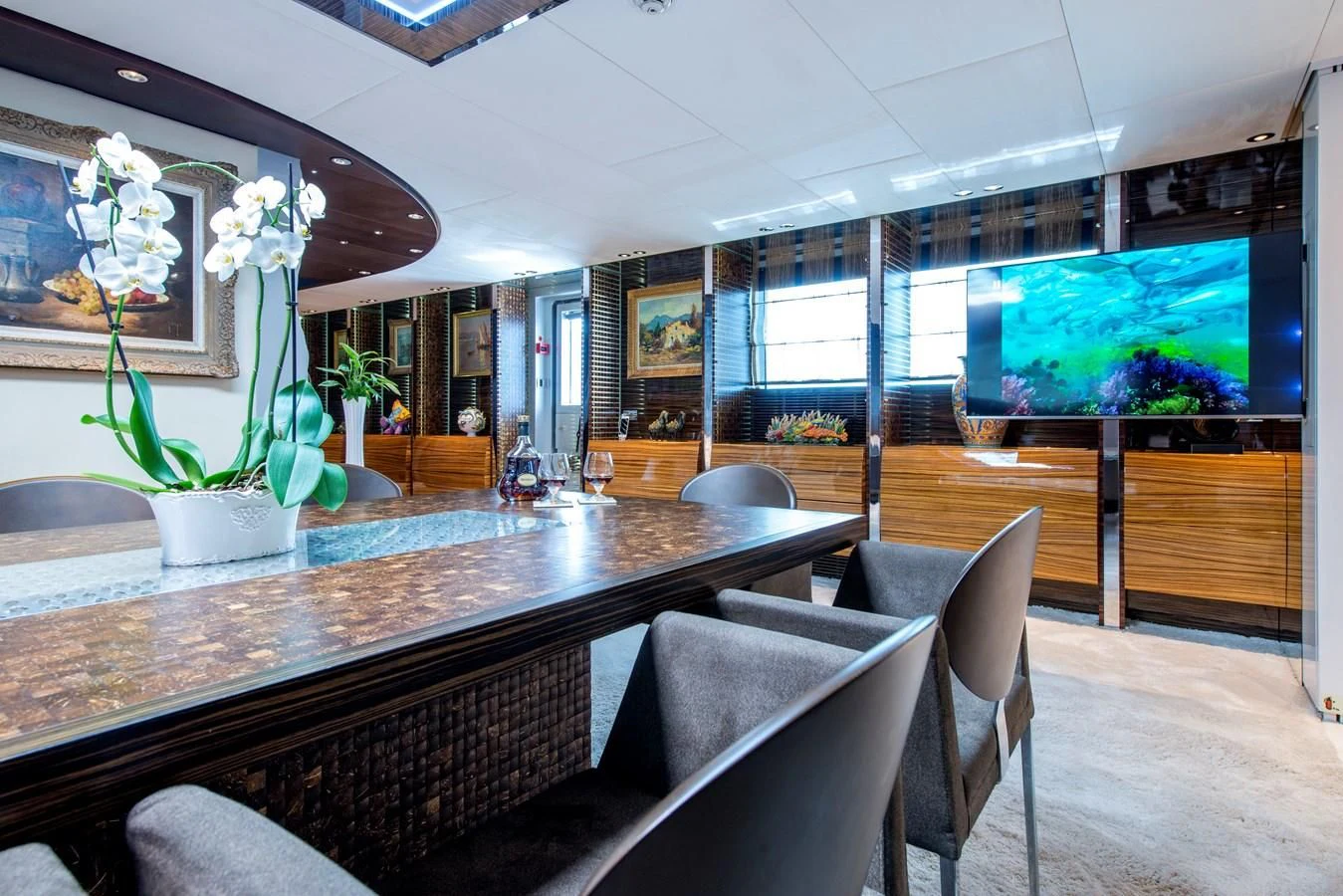 a room with a table chairs and a tv aboard TIAMAT Yacht for Sale