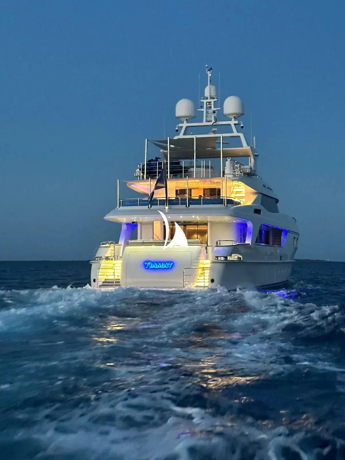 a large boat in the water with Yasawa Islands in the background aboard TIAMAT Yacht for Sale