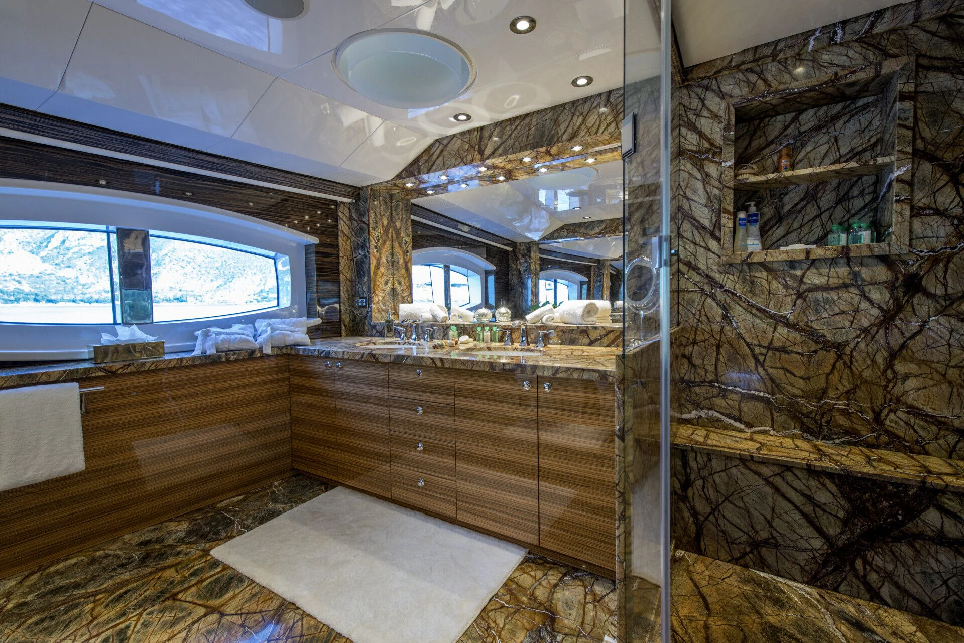 a room with a large shelf of books and a rug aboard TIAMAT Yacht for Sale