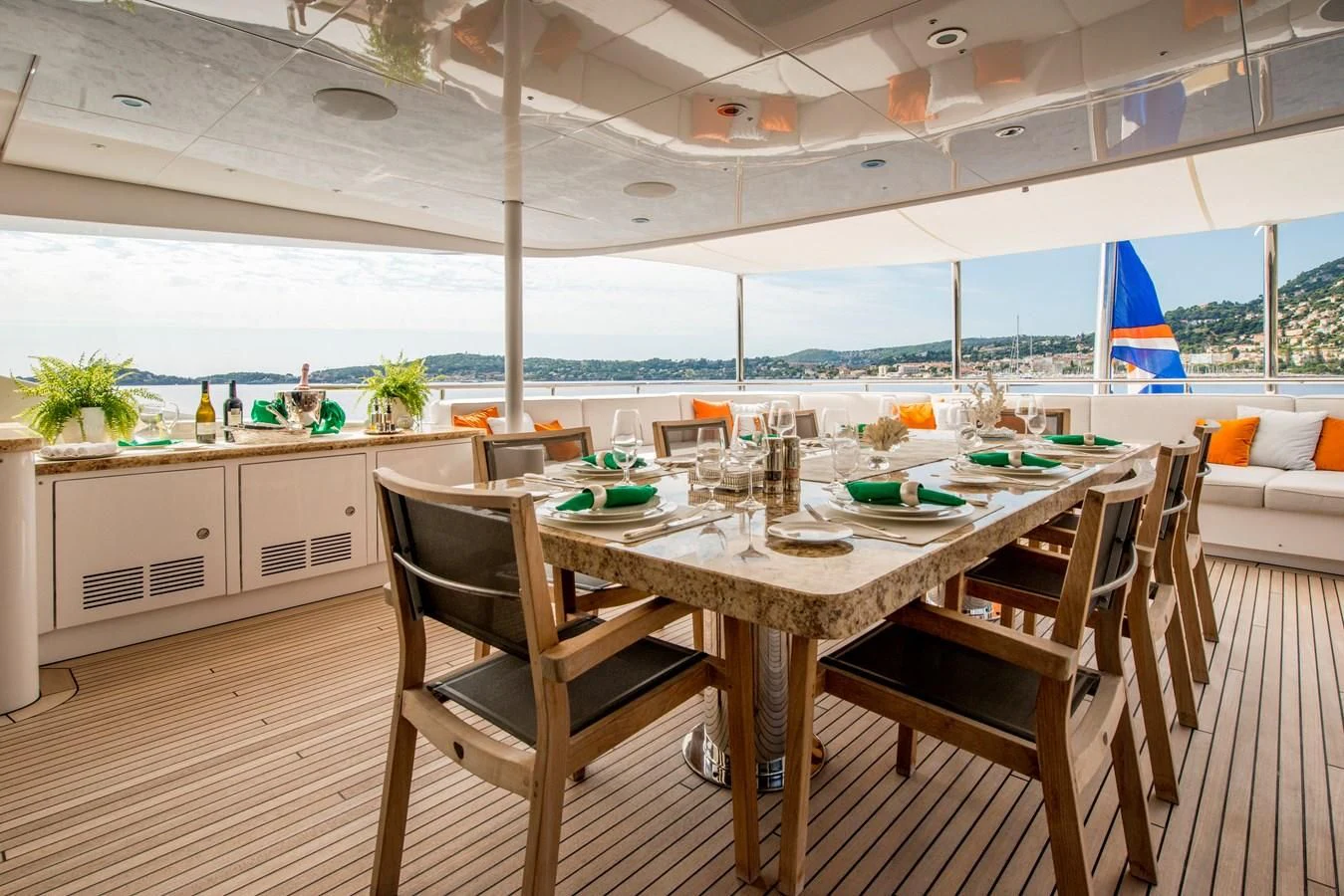a table with chairs and a couple of chairs in a room with a large window and a view aboard TIAMAT Yacht for Sale