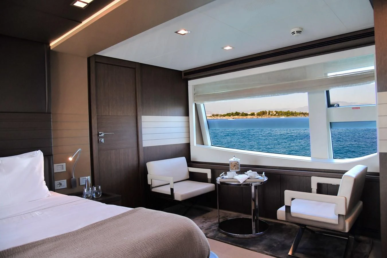 a room with a bed and a table and a window aboard CUSTOM LINE 100 Yacht for Sale