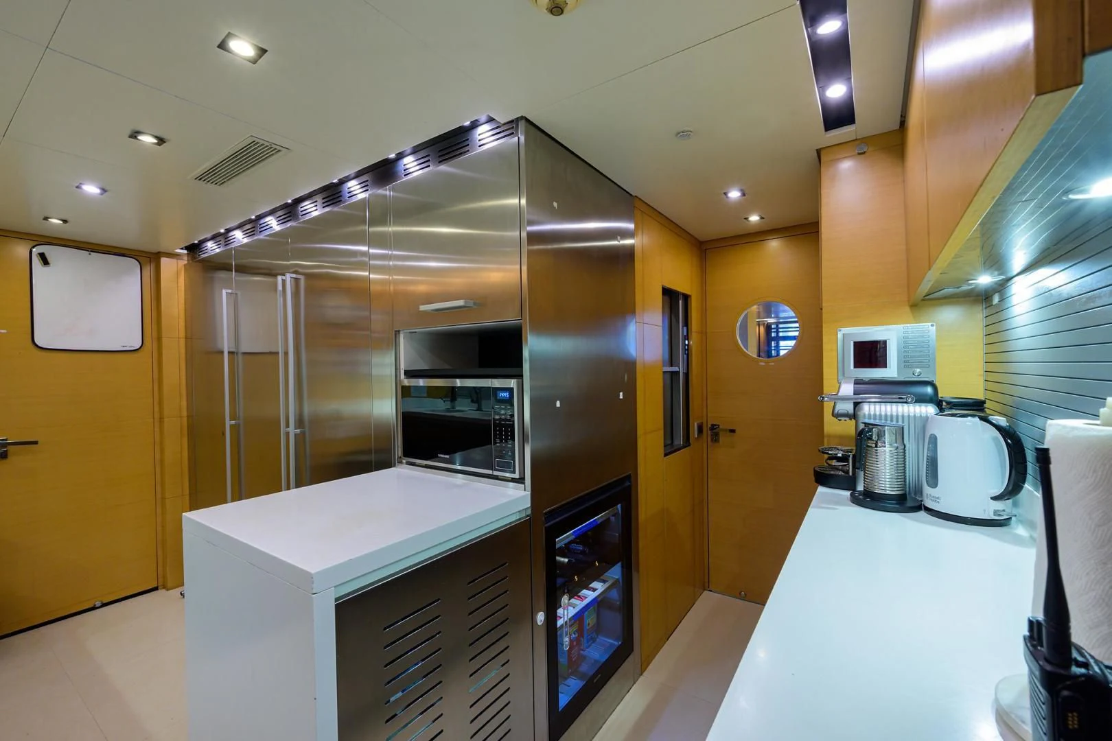 a kitchen with a microwave oven and refrigerator aboard AWAY Yacht for Charter
