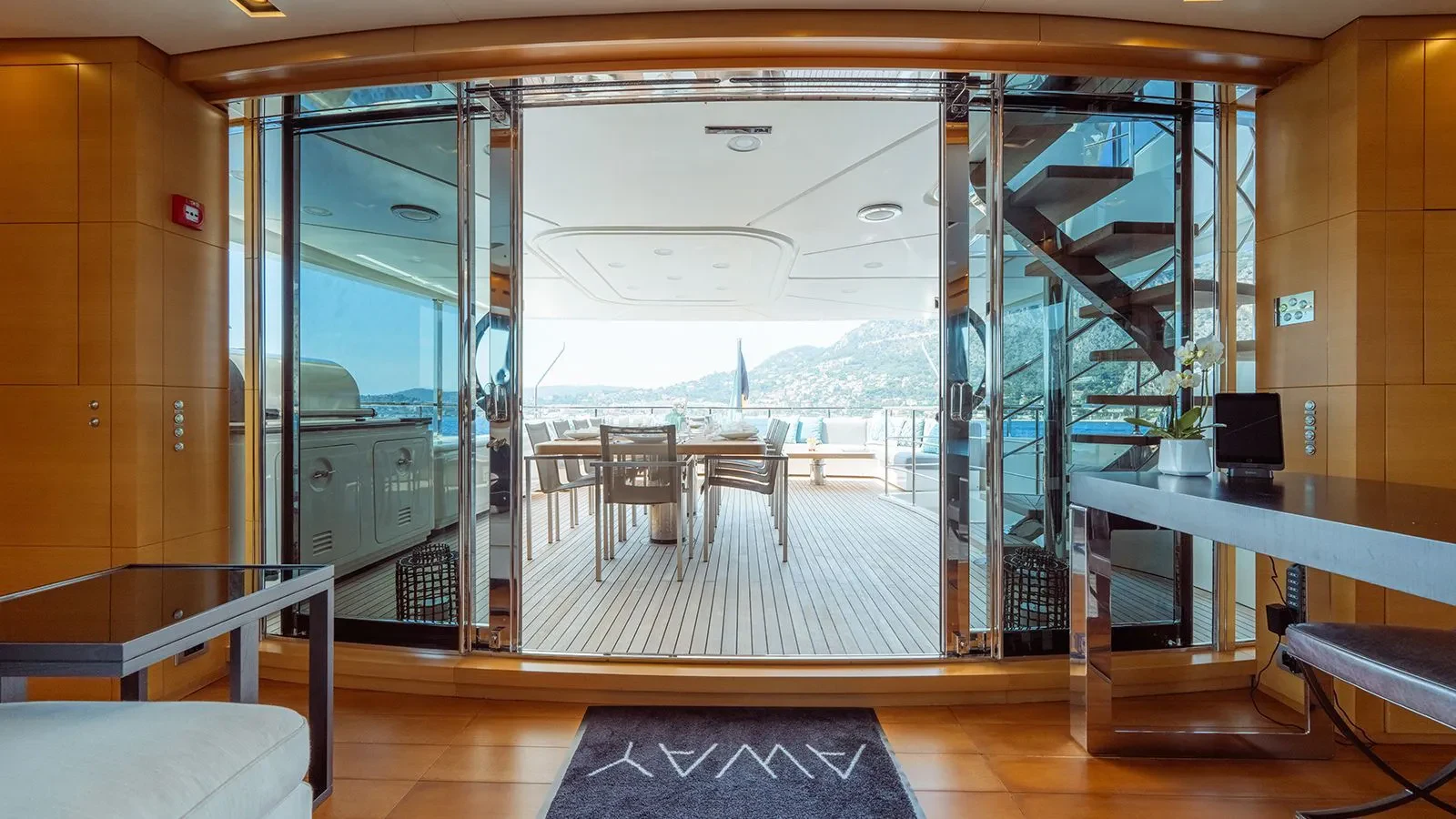 a room with a glass door and a table and chairs aboard AWAY Yacht for Charter