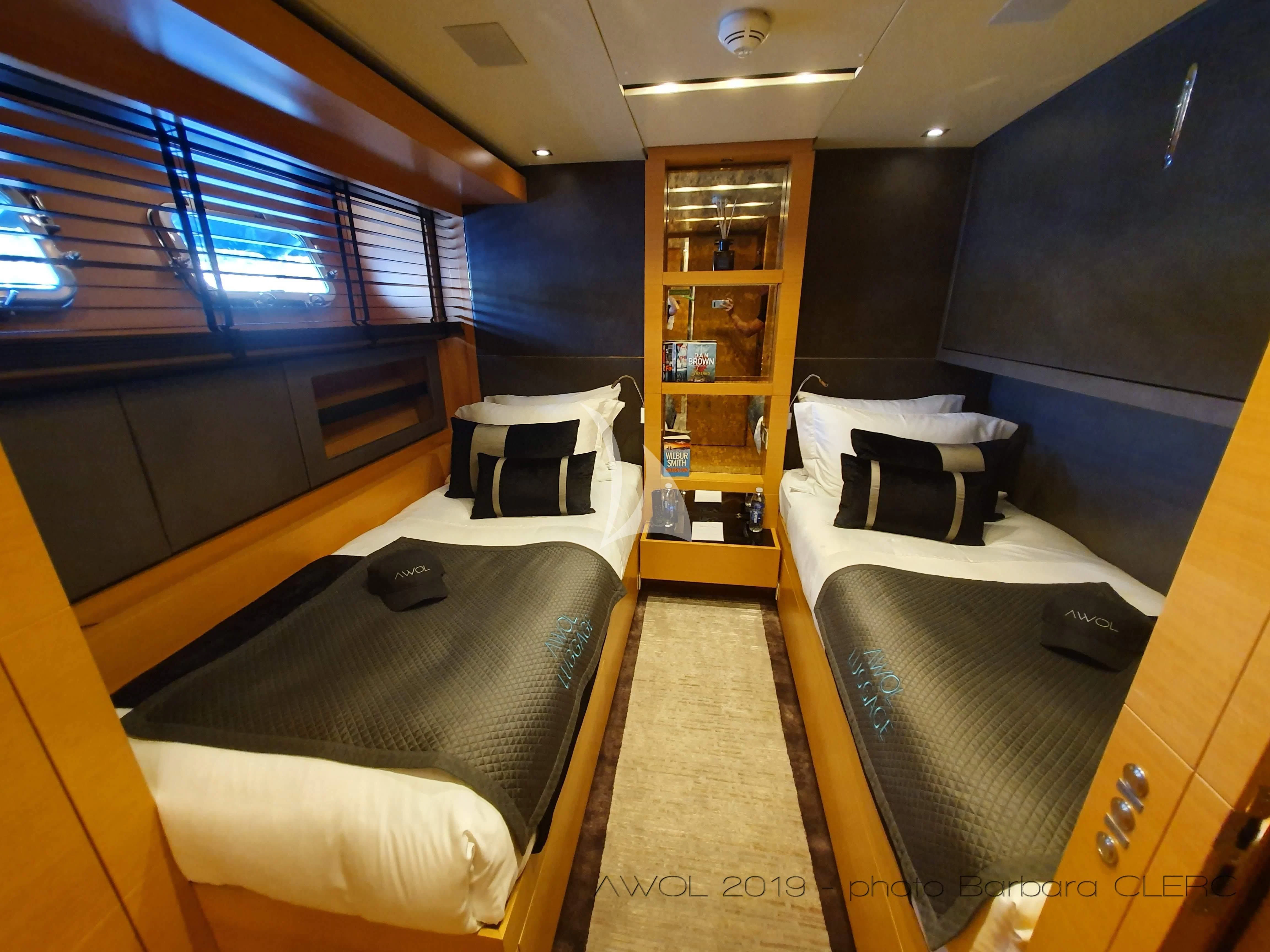 a room with a bed and a shelf with a bookcase aboard AWAY Yacht for Charter