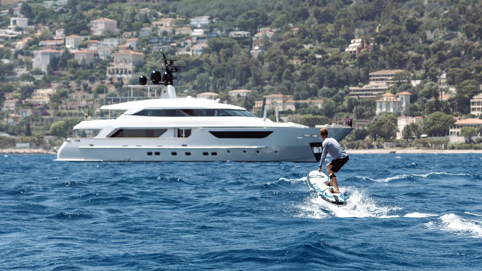 a man surfing on the sea aboard AWAY Yacht for Charter