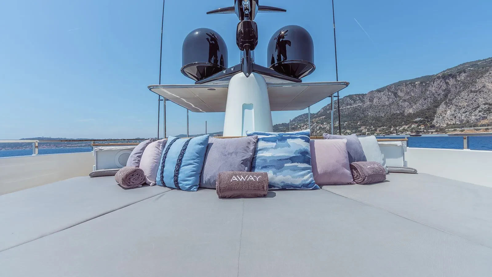 a bed with a white bed spread and a white tent with a white roof and a large fan aboard AWAY Yacht for Charter