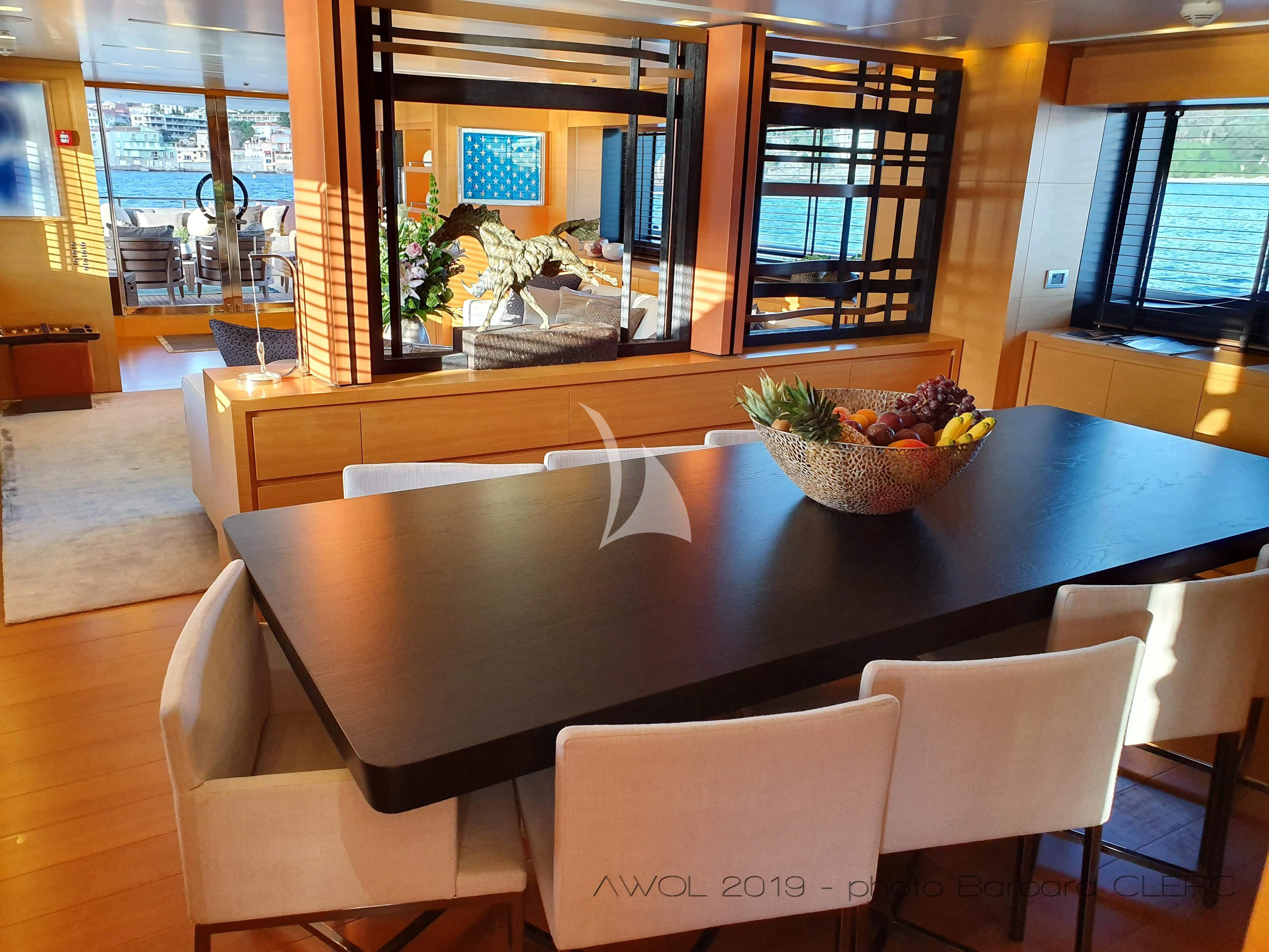 a table with chairs and a bowl of fruit on it aboard AWAY Yacht for Charter