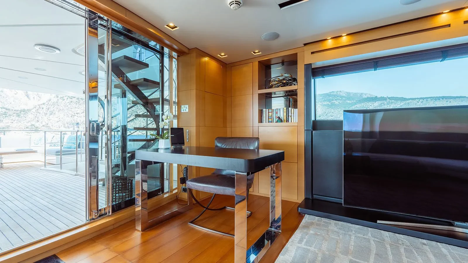 a room with a desk and a large window aboard AWAY Yacht for Charter