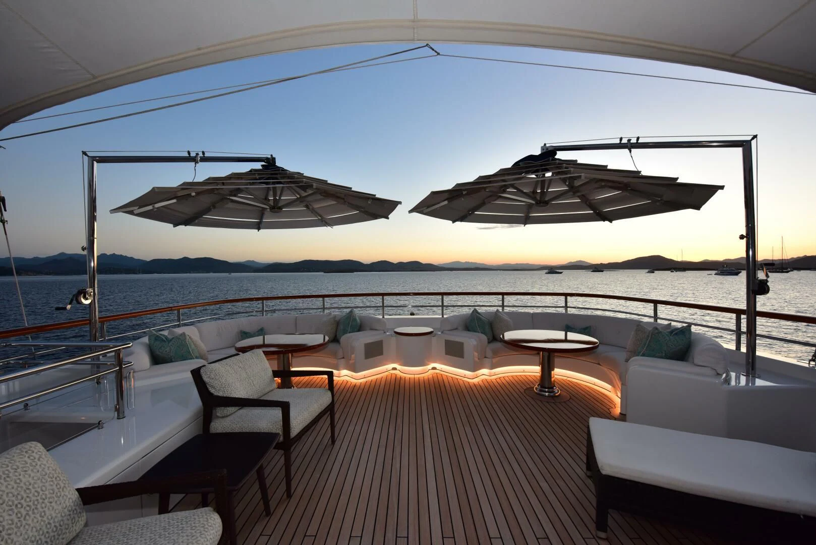 a lounge area with a large white lounge chair and a large body of water aboard HALCYON Yacht for Sale