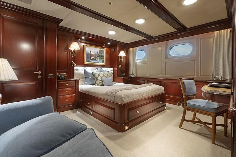 a bedroom with a bed and a desk aboard HALCYON Yacht for Sale