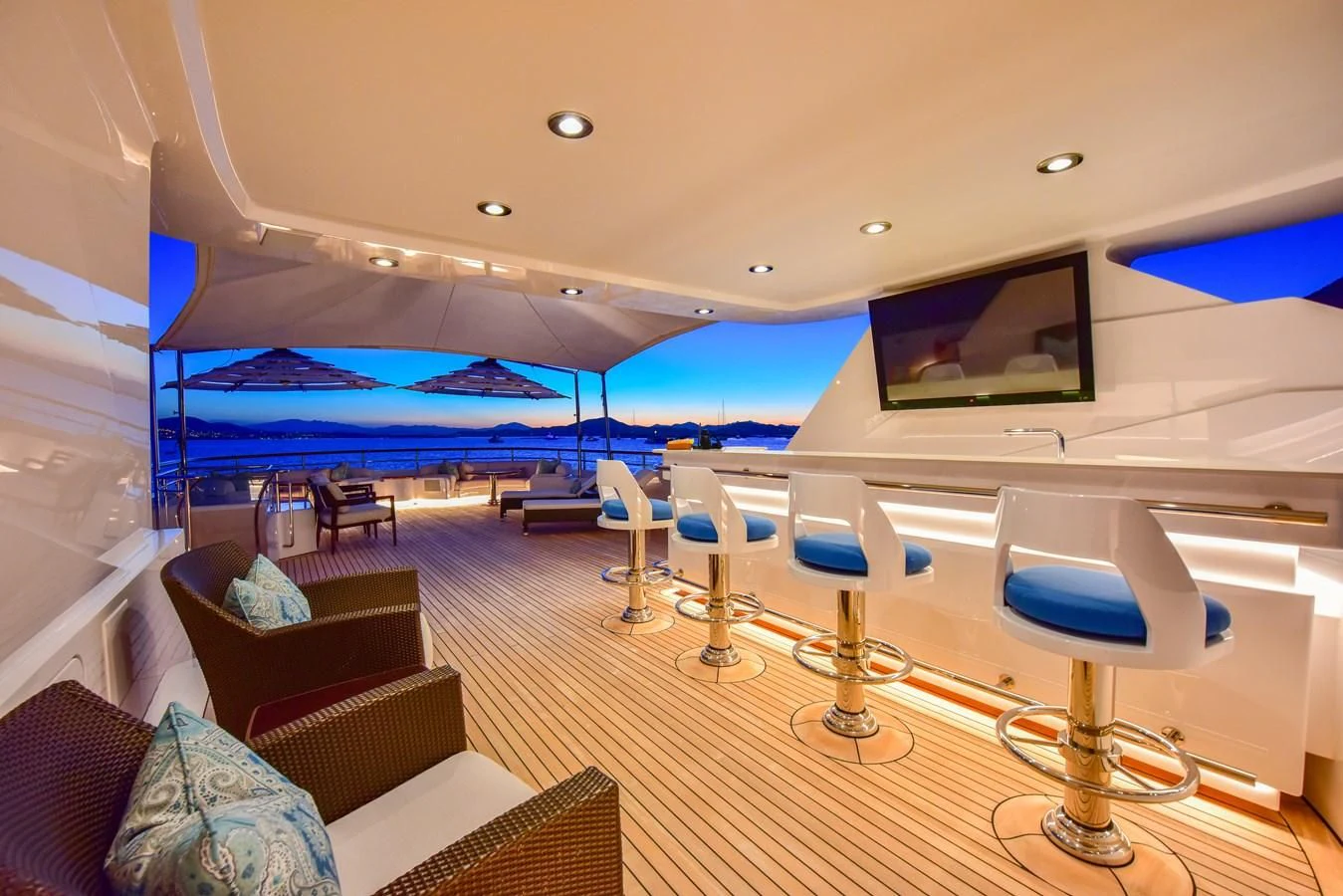 a room with a large screen and chairs and a table with a large blue and white screen and aboard HALCYON Yacht for Sale