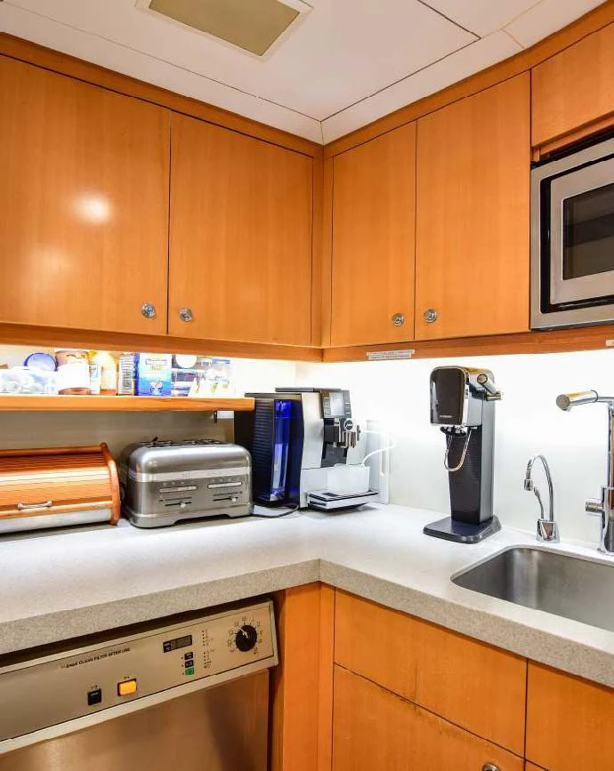 a kitchen with wooden cabinets aboard HALCYON Yacht for Sale