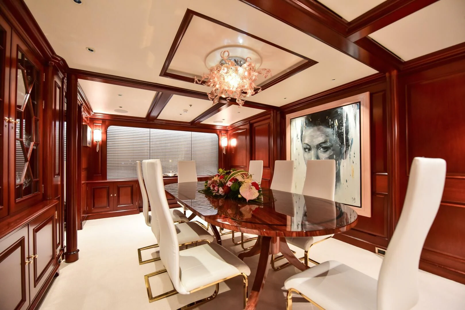 a room with a table chairs and a chandelier aboard HALCYON Yacht for Sale