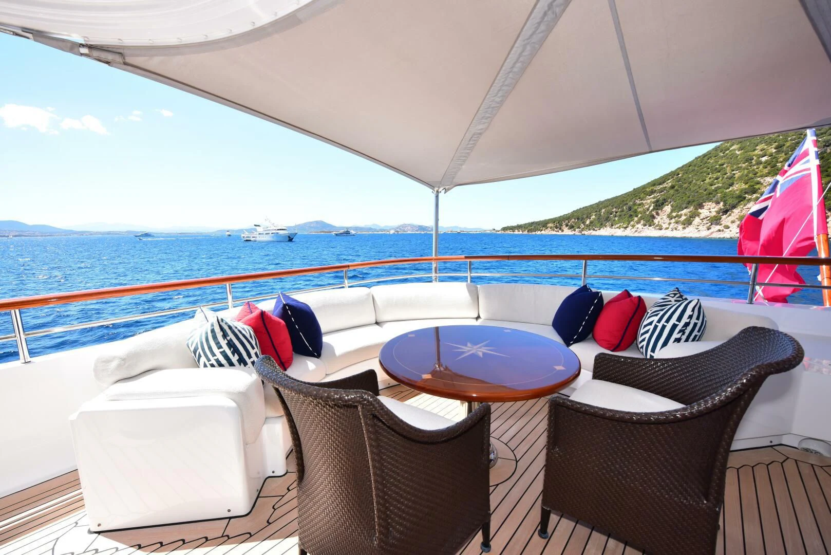 a table and chairs on a deck overlooking a large body of water aboard HALCYON Yacht for Sale
