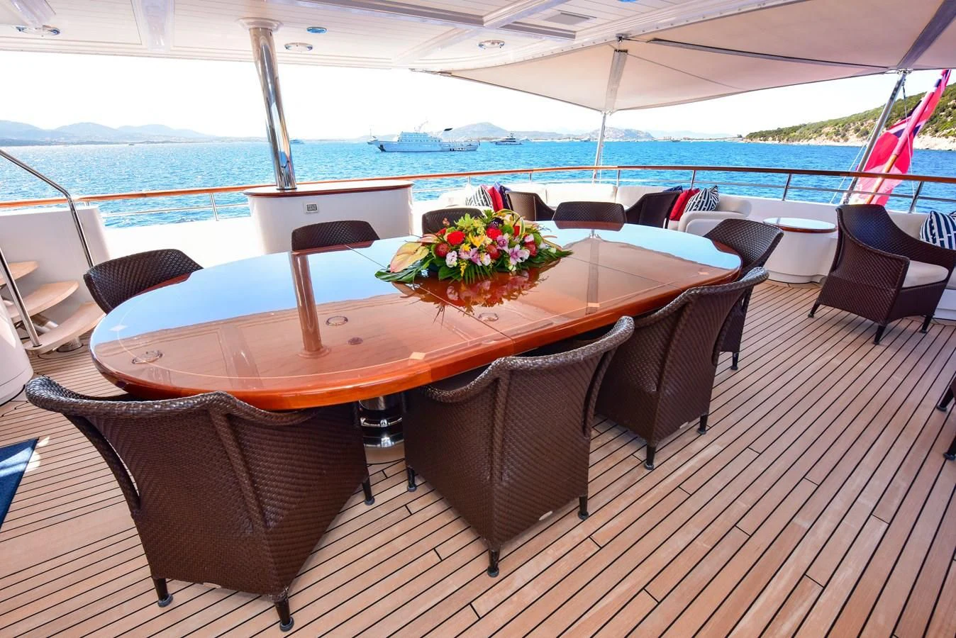 a table with chairs and a large body of water in the background aboard HALCYON Yacht for Sale