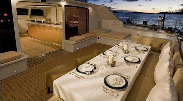 a table with plates and glasses on it aboard MAGIC CAT Yacht for Sale
