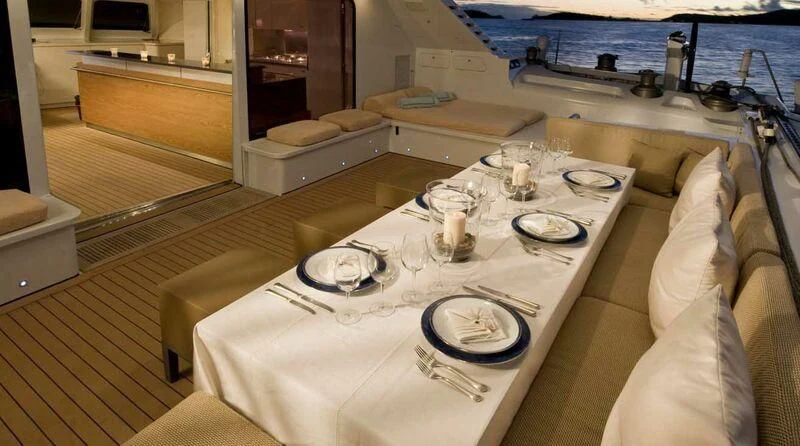 a table with plates and glasses on it aboard MAGIC CAT Yacht for Sale