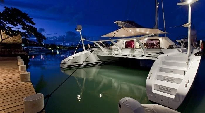 a white boat docked at a pier aboard MAGIC CAT Yacht for Sale