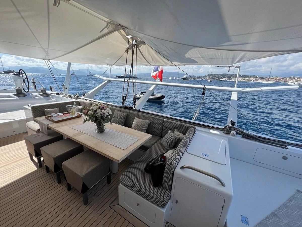 a boat with a table and chairs aboard MAGIC CAT Yacht for Sale