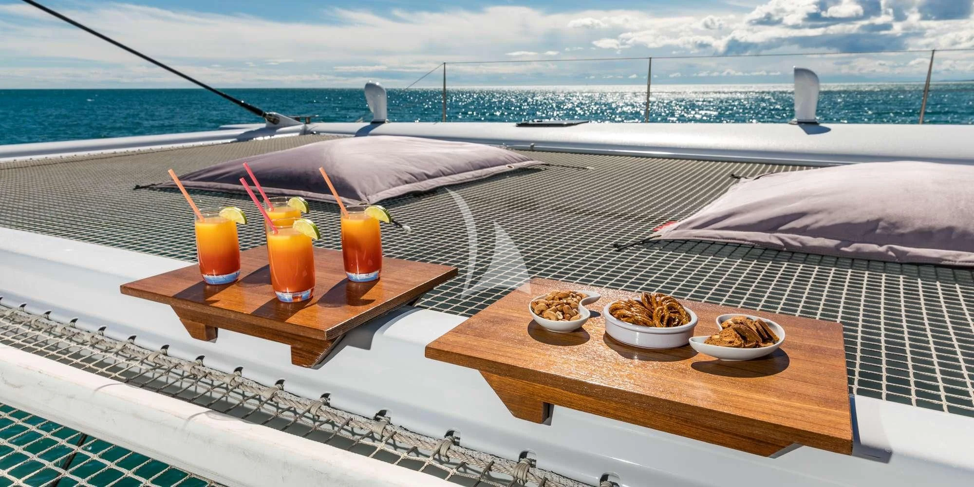 a table with food and drinks on it by the ocean aboard MAGIC CAT Yacht for Sale