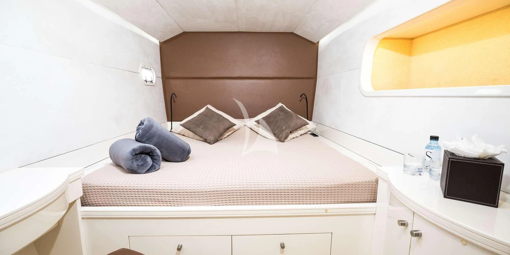 a bed with a white sheet and a television on top of it aboard MAGIC CAT Yacht for Sale