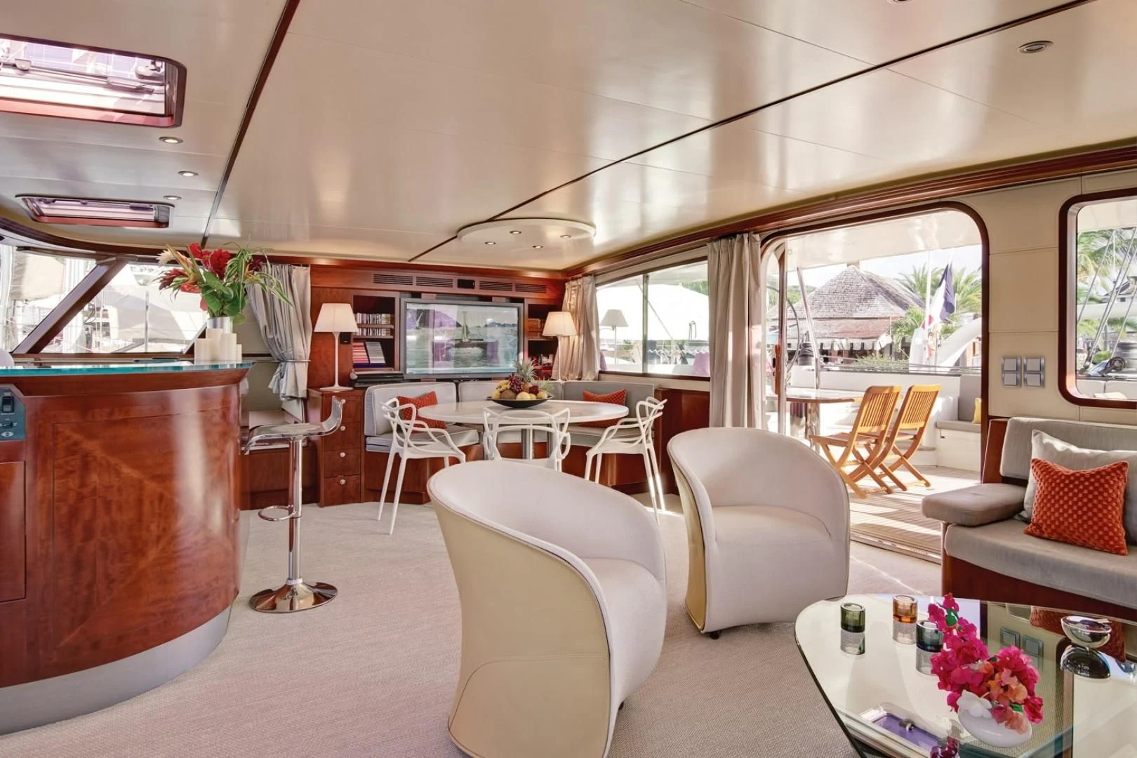 a room with a table chairs and a television aboard MIROVIA Yacht for Charter